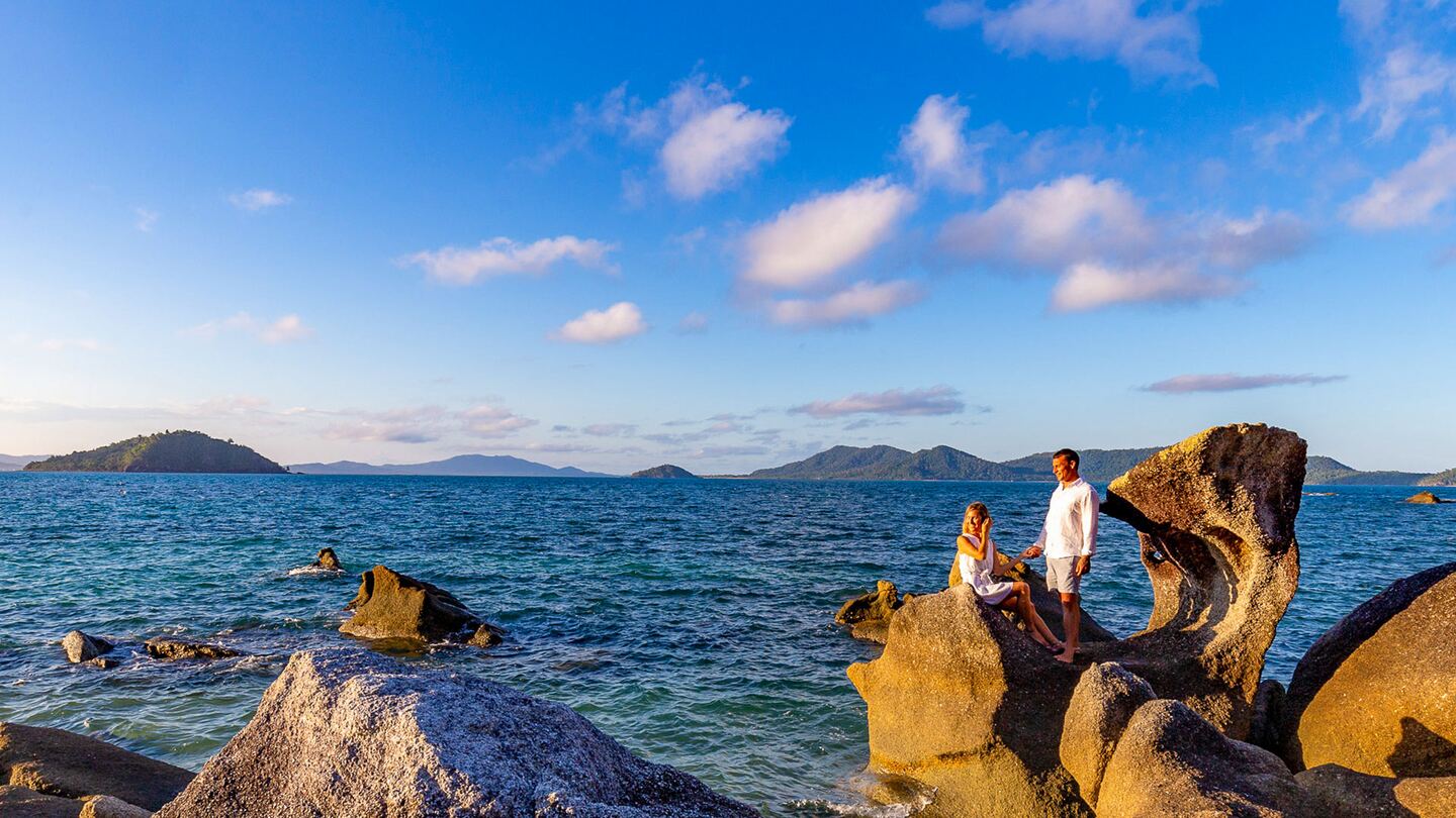 Two guests on the granite boulders looking out across the Coral Sea