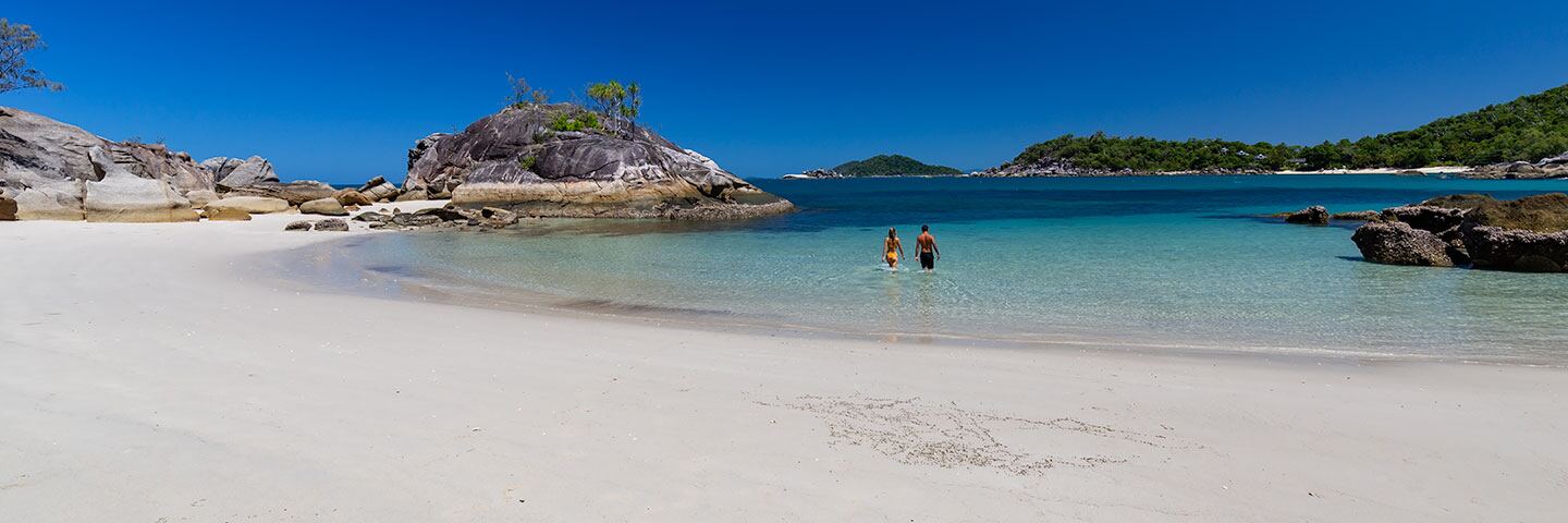Wide view along the beach with guests in the shallow water